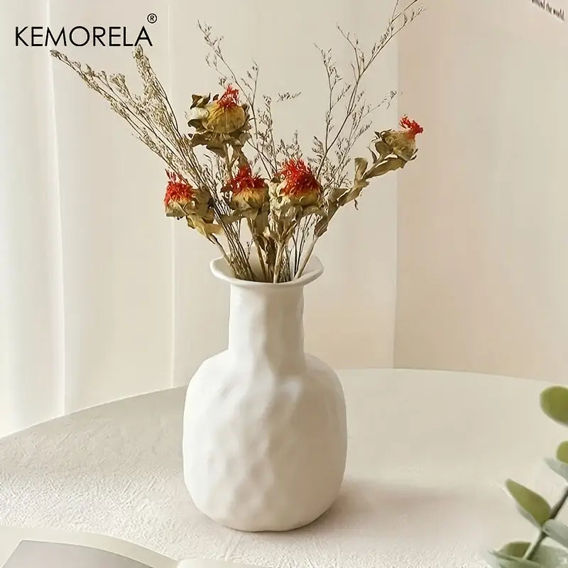 White textured nordic ceramic vase with slender neck and rounded body holding dried flowers for home decor accent