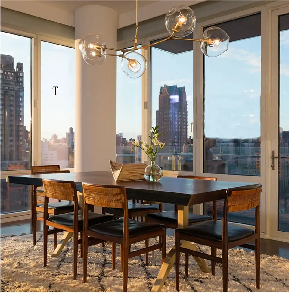 Modern dining table with dark wood top and light wooden legs with woven chairs under decorbites™ nordic chandelier for living rooms
