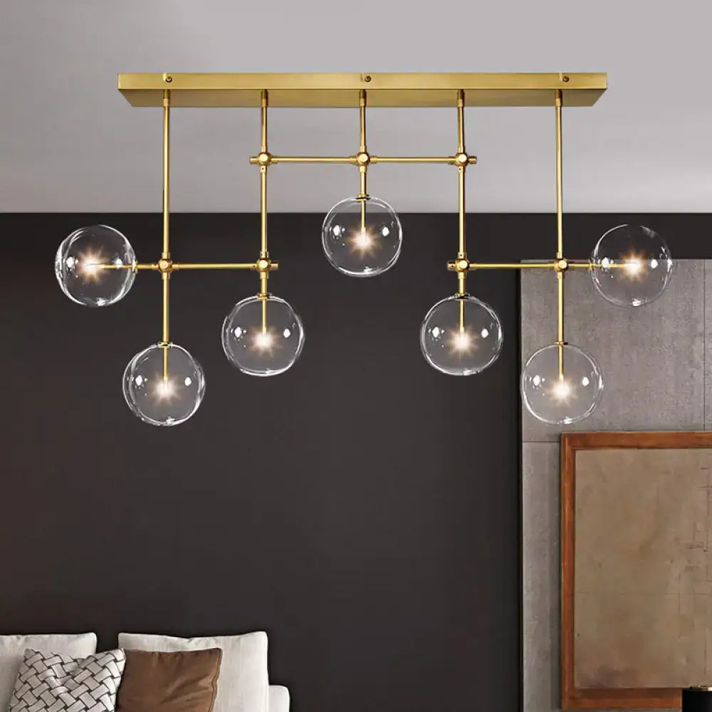 Modern brass ceiling light with five clear glass globes suspended from a geometric frame 220v-240v