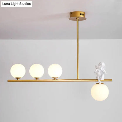 Gold-toned DecorBites™ Nordic Island Angel pendant light with three opaline glass shade bulbs and white cherub figurine