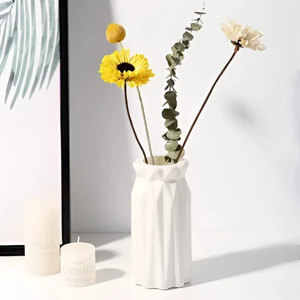 White ceramic nordic plastic vase with geometric faceted design and slightly flared rim for modern home decor