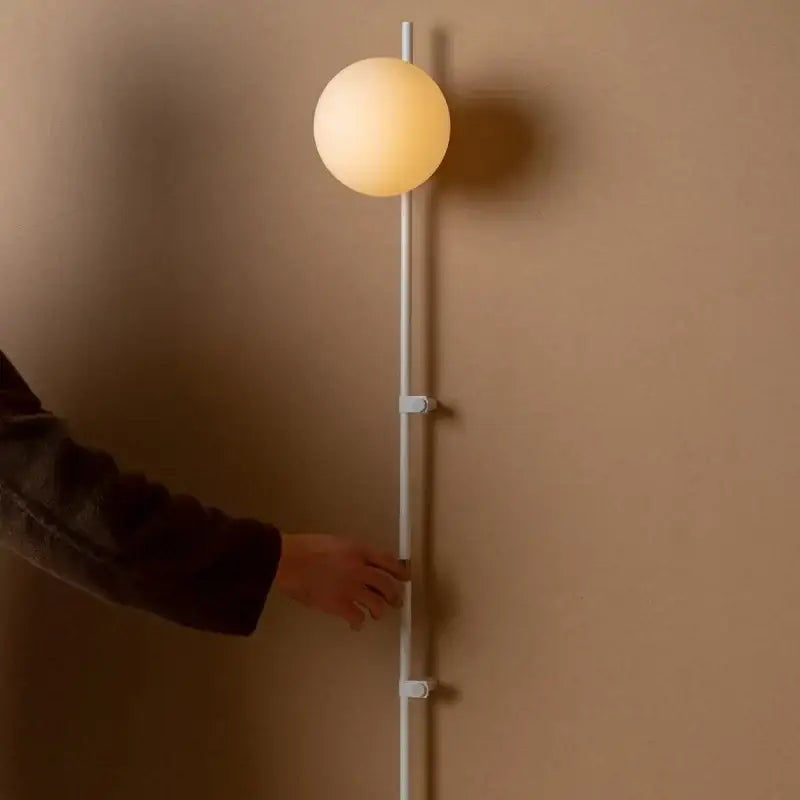 Decorbites™ nordic plug in wall lamp sconce with a sleek white cylindrical pole and warm glowing spherical glass shade lamp sconce