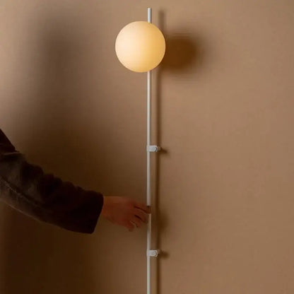 Decorbites™ nordic plug in wall lamp sconce with a sleek white cylindrical pole and warm glowing spherical glass shade lamp sconce