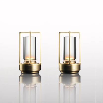 Two elegant brass-framed lanterns with clear glass cylinders and warm lighting in decorbites™ nordic rechargeable table lamp design