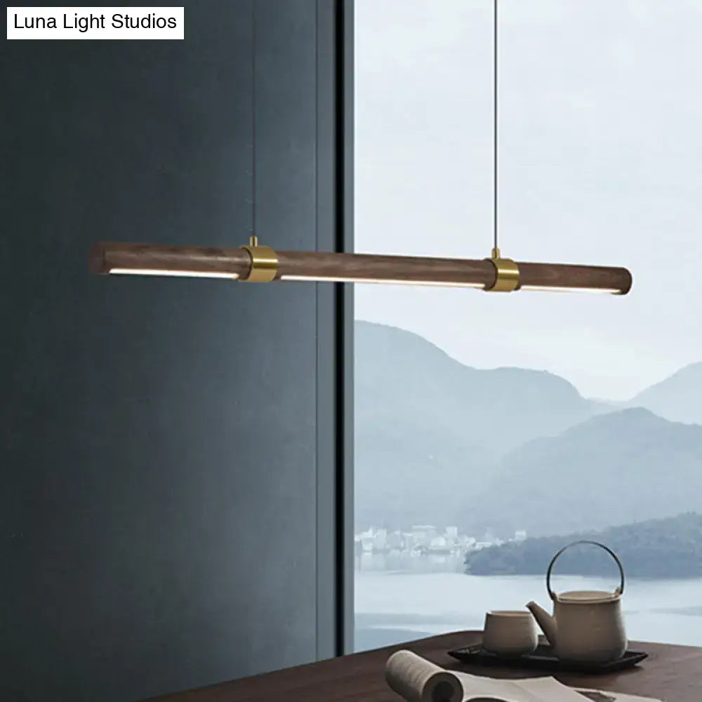 Modern minimalist wood island pendant with wooden barrel body and polished brass accents for dining table lighting