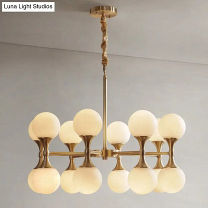 Decorbites opal glass chandelier light with 12 brass frosted globe heads in a modern symmetrical design