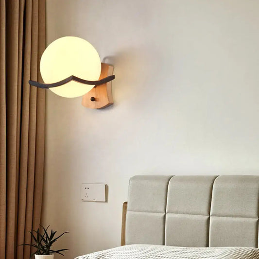 Warm-toned wood and opal glass globe wall sconce with wooden base and black accent for 110v-120v and 220v-240v use