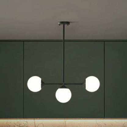 Modern black metal chandelier with three frosted opaline glass globes for minimalist dining room island lighting