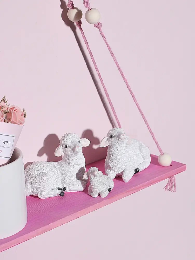 White ceramic sheep figurine set with textured surfaces and black bead accents displayed on pink green wooden wall shelf for kids room