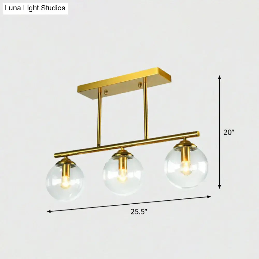 DecorBites™ postmodern brass island light with gold finish and three clear globe glass shades ceiling fixture