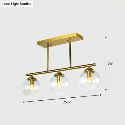 DecorBites™ postmodern brass island light with gold finish and three clear globe glass shades ceiling fixture