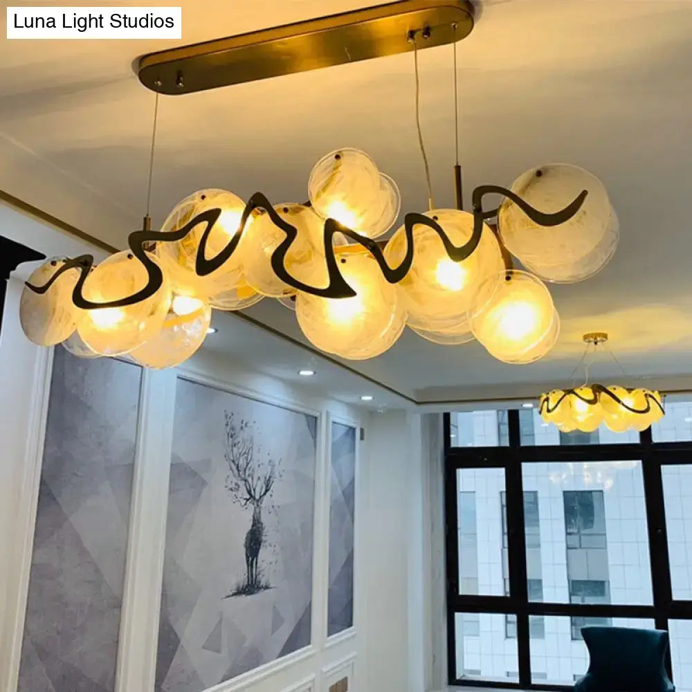 Gold-toned DecorBites postmodern circle pendant light with warm-glowing glass orbs and black sculptural elements LED fixture