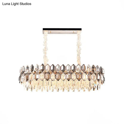 A modern DecorBites island light fixture with rectangular chrome frame and twisted crystal chains for dining room use