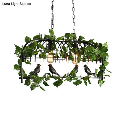 Black wrought iron retro birdcage island light fixture with artificial green vines and four bird figurines