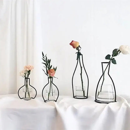 Minimalist black metal retro iron flower vase with clear glass base holding a single rose or greenery for decor