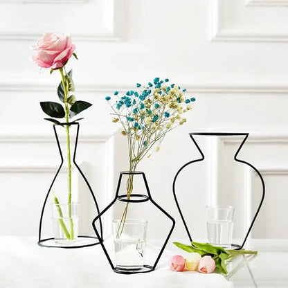 Three minimalist black retro iron flower vases with wireframe design and clear glass bases for home and garden decor