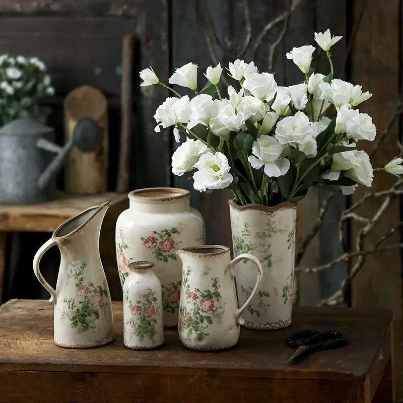 A rustic cream-colored ceramic vase with floral pattern and distressed edges in retro nordic ceramic style
