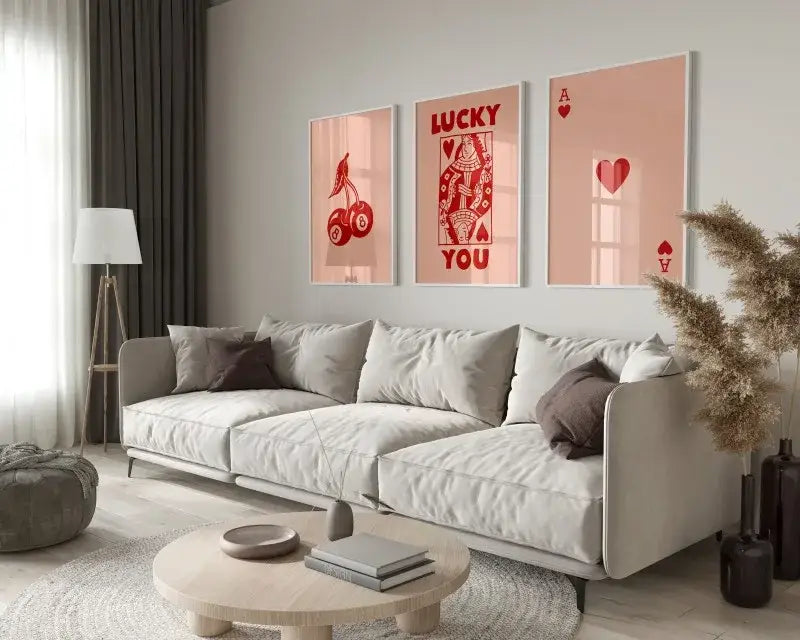 Light gray upholstered sofa with dark brown throw pillows beside decorbites retro wall art posters set queen of hearts theme