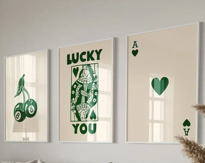 Set of three framed retro wall art prints with green playing card and lucky charm designs on cream background by decorbites