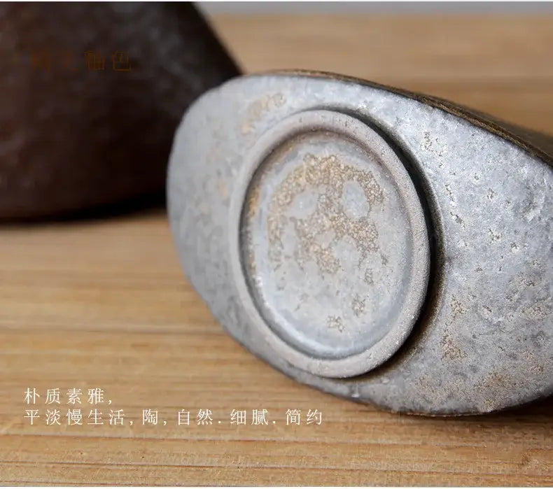A rustic oval ceramic inkstone with a matte gray surface and golden speckles for pottery vase ornaments and tea ceremony
