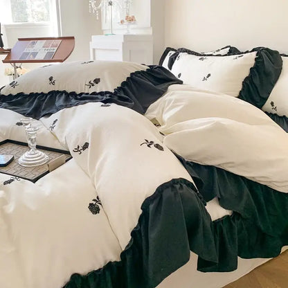 Cream-colored DecorBites™ rose embroidered duvet cover set with black ruffled trim in princess style cover set