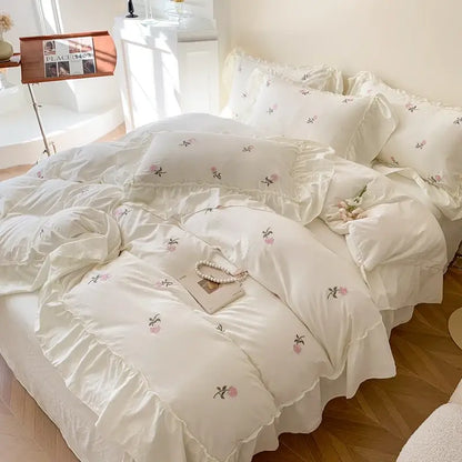 Cream-colored DecorBites™ rose embroidered duvet cover set with delicate pink green floral embroidery and ruffled edges