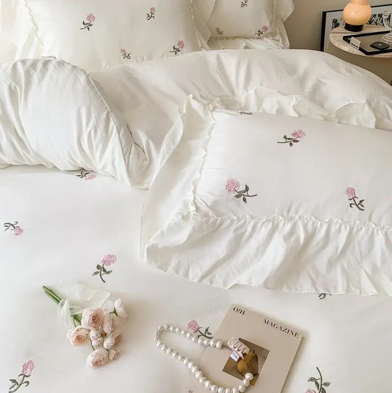 White pillow with delicate pink rose embroidery and ruffled edges from decorbites rose embroidered duvet cover set princess style