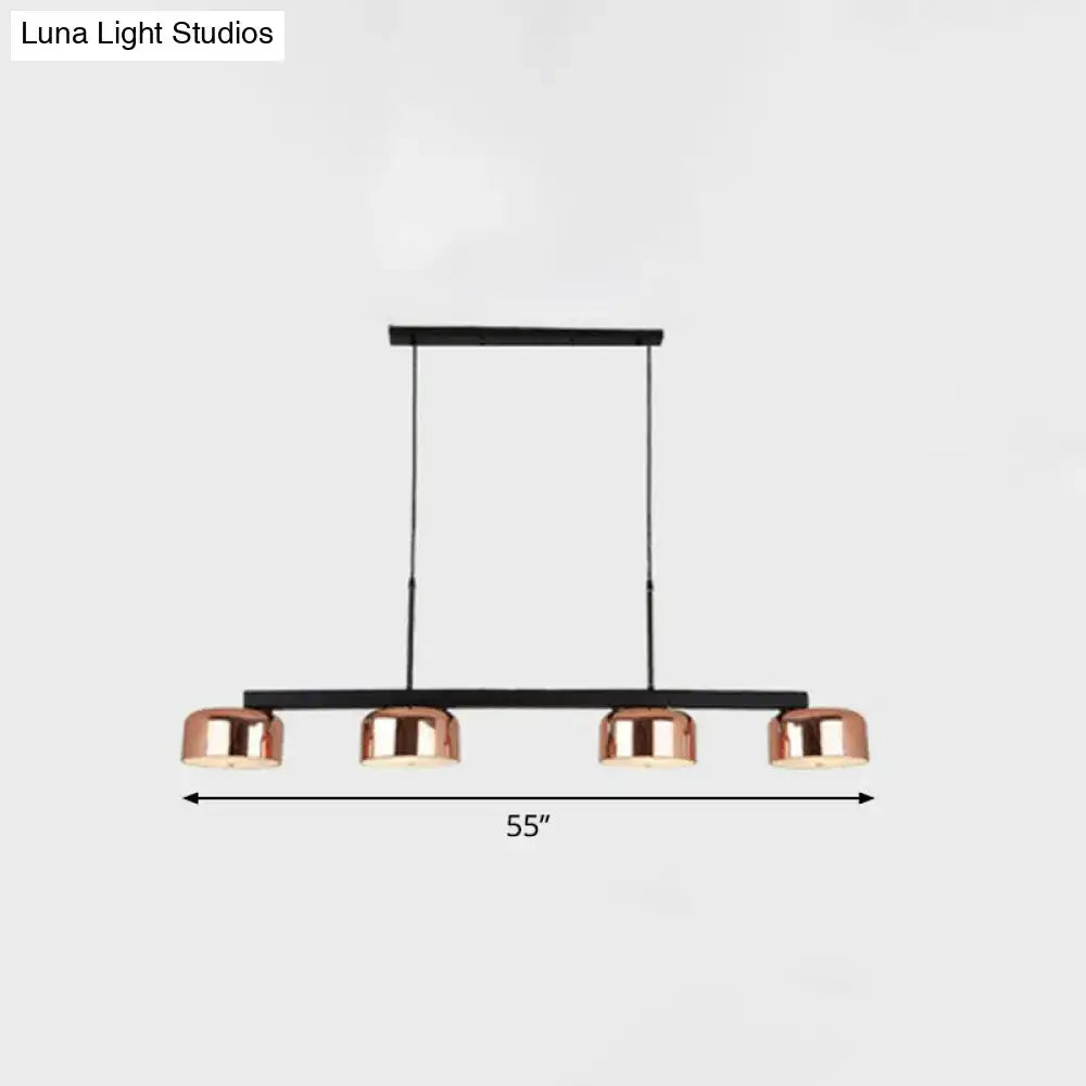 DecorBites rose gold metal pendant light fixture with four cylindrical shades for minimalist dining room