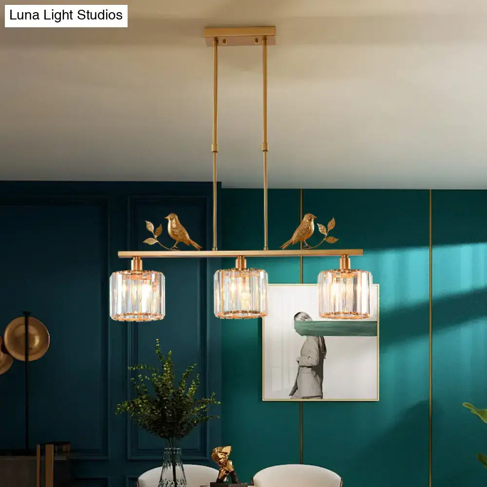 Gold-toned pendant light with three cylindrical glass shades and bird decor for dining room cylindrical crystal island lighting