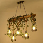 Rustic wooden brown island light with five cage shade lanterns and green art ivy pendant by DecorBites