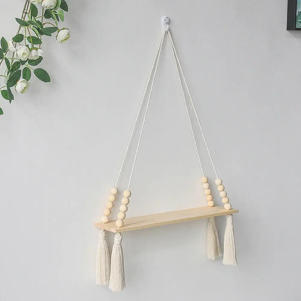DecorBites™ rustic wooden wall shelf with natural wood finish hanging by white macrame cords with beads and tassels