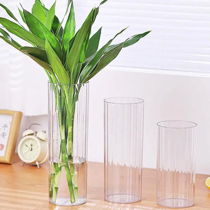 Decorbites shatterproof clear acrylic flower vase with ribbed design holding a lush green bamboo plant