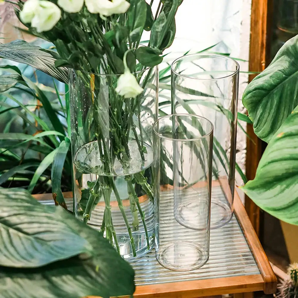 DecorBites™ shatterproof tall transparent acrylic flower vase with clear cylindrical design holding white flowers and water