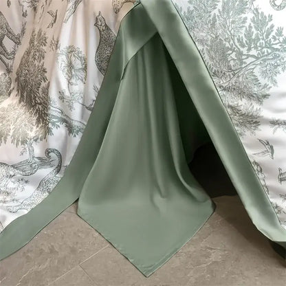 A soft sage green eucalyptus fiber duvet cover draped to form a cozy tent-like bed sheet structure