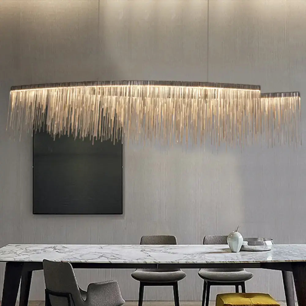 Decorbites silver metallic tassel chain led pendant light with cascading golden strands above marble dining table