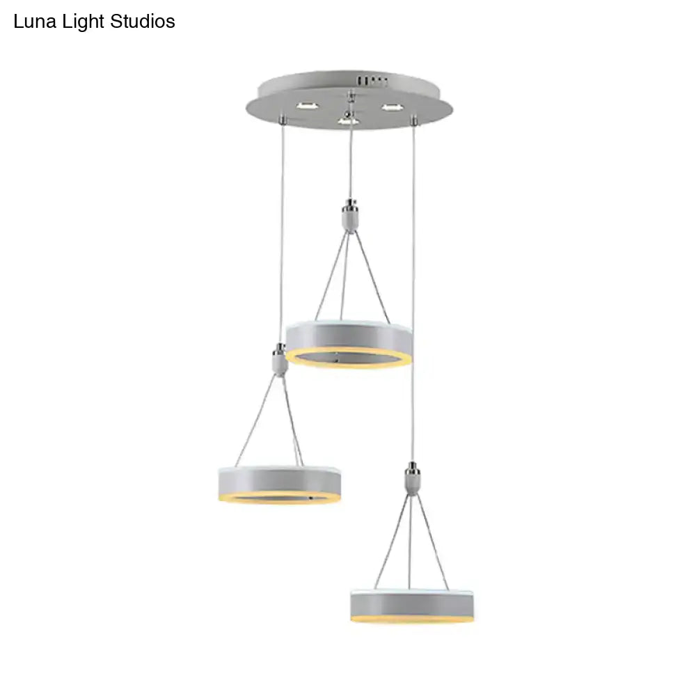 Modern white and silver cluster ceiling light with sleek metallic rings and warm yellow led glow for dining room