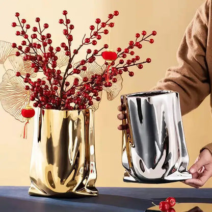 Shiny gold and silver metallic silver ruffled flower vase with a sculpted bag-like ceramic design by DecorBites