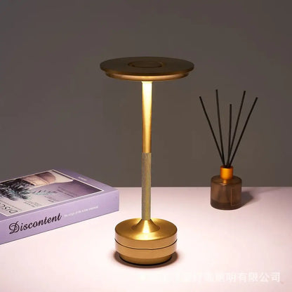 Gold-colored minimalist decorbites™ simple charging led desk lamp with cylindrical base and textured grip section