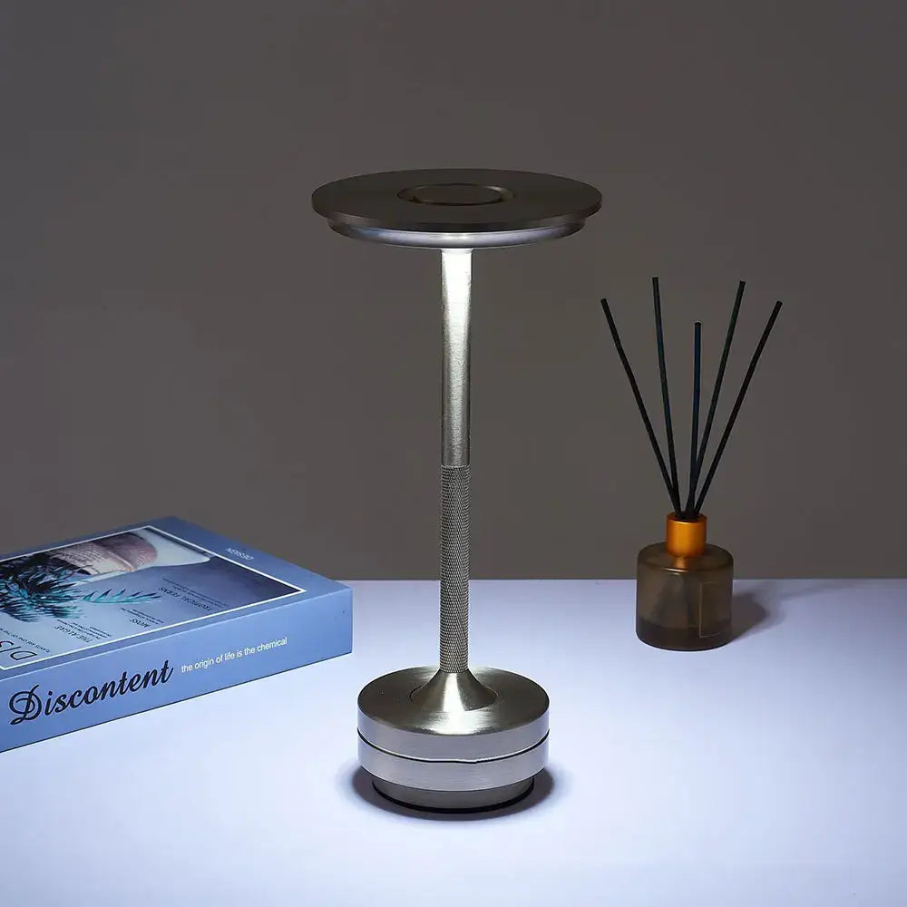 Silver-toned minimalist decorbites™ simple charging led desk lamp with cylindrical stem and circular base for restaurant bar use