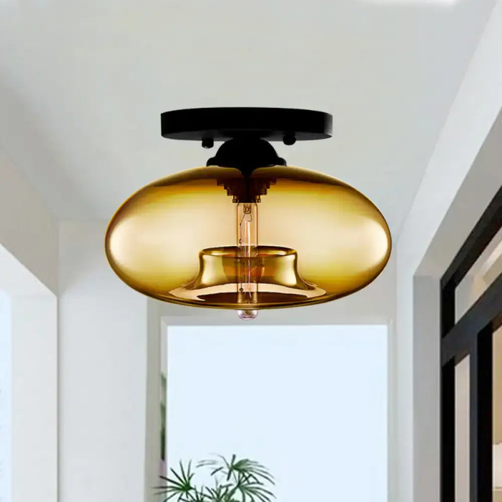 Amber-colored glass oval flush mount pendant light with black metal ceiling mount for hallway lighting