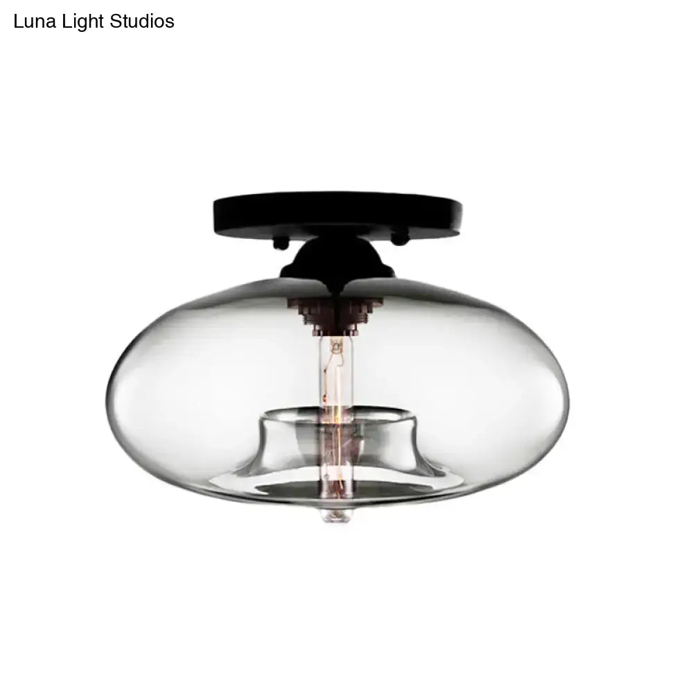 Decorbites™ simple style oval flush mount lamp with a black metal base and smoky glass oval flush housing an exposed bulb