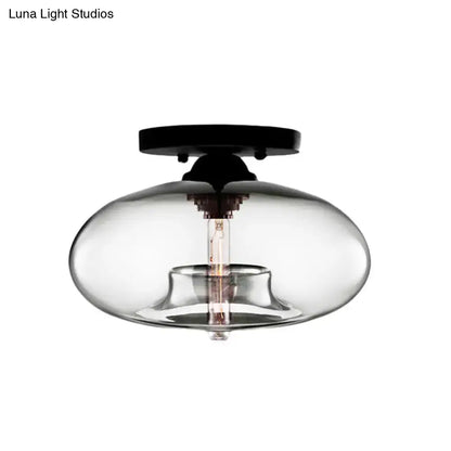 Decorbites™ simple style oval flush mount lamp with a black metal base and smoky glass oval flush housing an exposed bulb