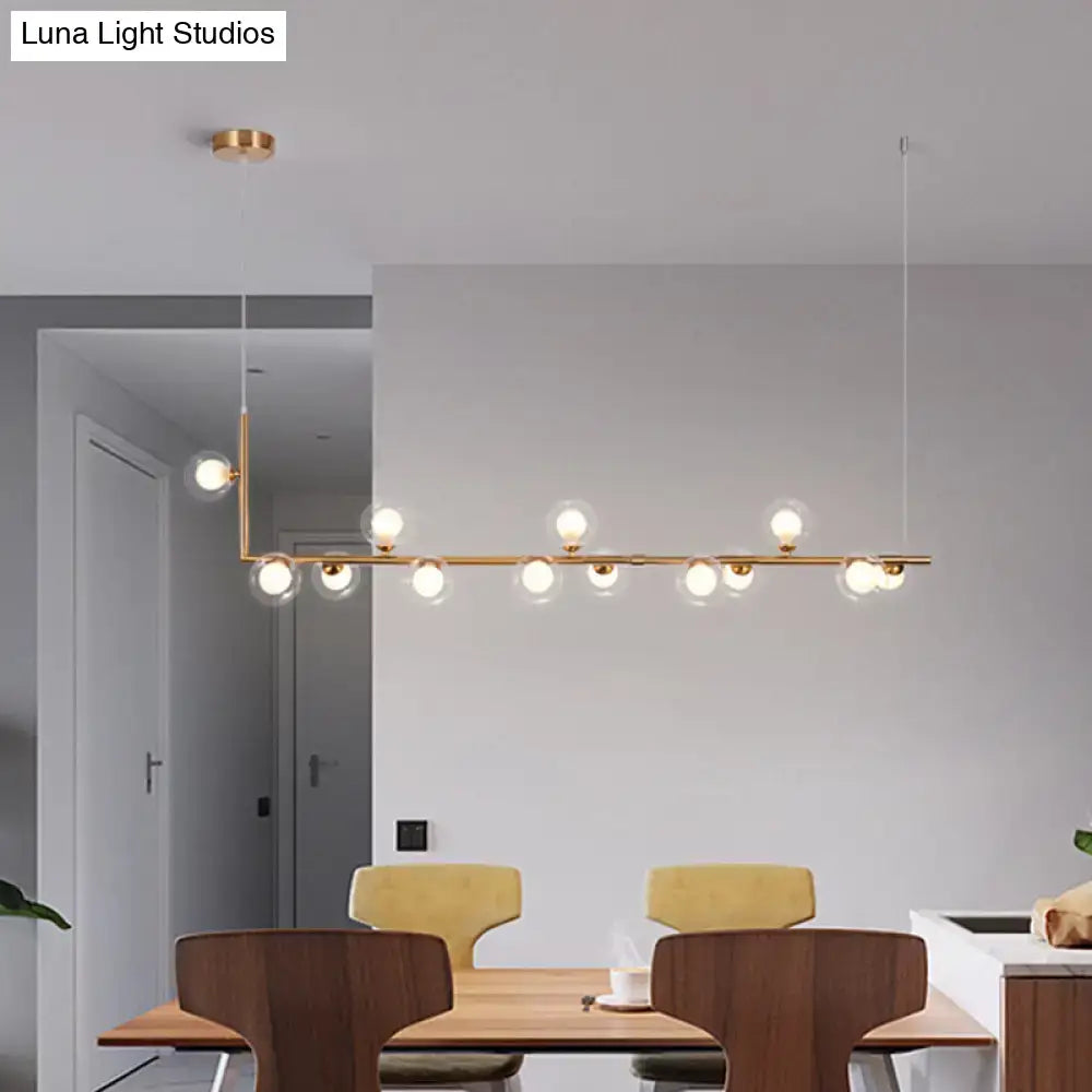 Modern gold-toned linear pendant light with multiple spherical glass bulbs for dining room hanging island decor