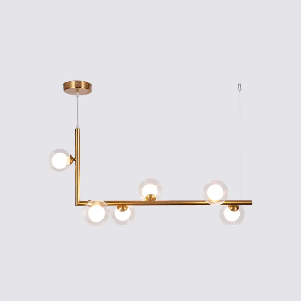 Modern gold-toned DecorBites pendant light with five clear glass globes for dining room hanging island design