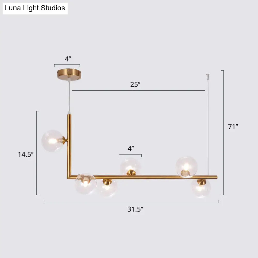 DecorBites sleek glass pendant light with brass finish and five clear globes in an l-shaped dining room hanging island design
