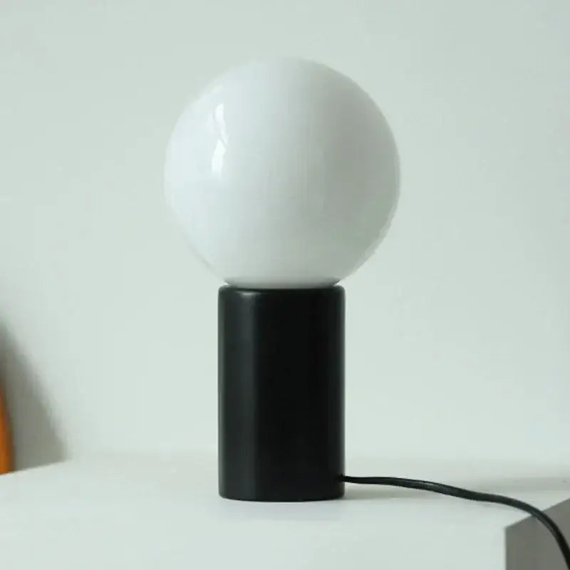 DecorBites™ small table lamp with a sleek black cylindrical base and smooth opaque white glass spherical shade