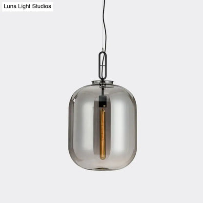 A sleek decorbites smoke gray cognac glass pendant lamp with black metal chain and exposed filament bulb
