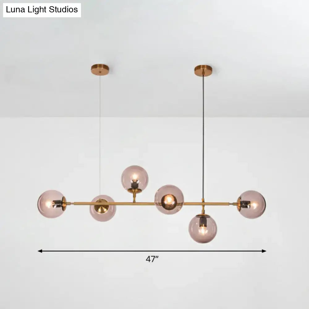 Decorbites smoke grey glass island pendant light with brass finish featuring six frosted spheres suspended by black cords