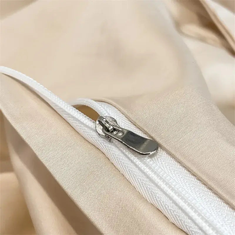 A sleek silver zipper with a metallic pull tab on a beige soft egyptian cotton duvet cover from decorbites