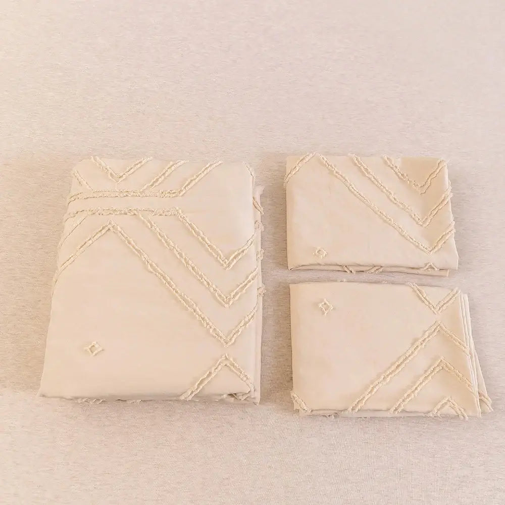 Cream-colored embroidered napkins with zigzag stitching complement the DecorBites™ soft tufted microfiber duvet cover set